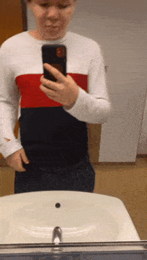 a person is taking a picture of themselves in a bathroom mirror
