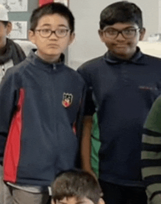 a group of young boys are standing next to each other in a classroom .