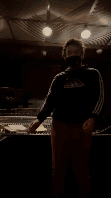 a man wearing a mask and an adidas hoodie