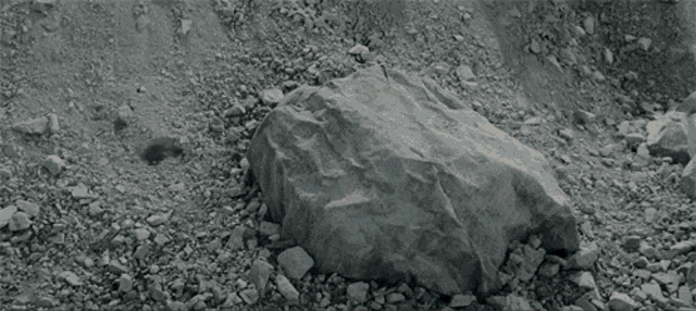 a child is laying on the ground with a blanket on his head