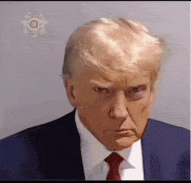 donald trump is wearing a suit and tie and making a funny face