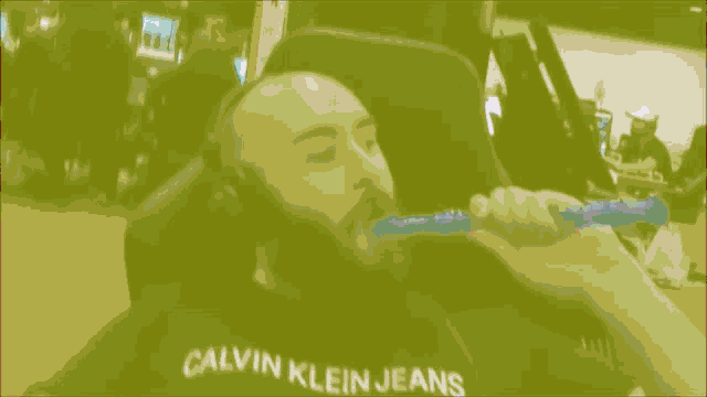 a man with a beard is laying down with his eyes closed and his shirt says jeans