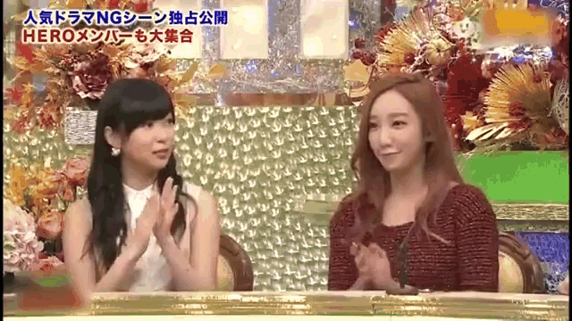 two women sitting at a table with flowers in the background and the words hero on the bottom