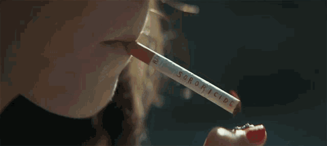a close up of a person smoking a cigarette that says ' s. cigarettes ' on it