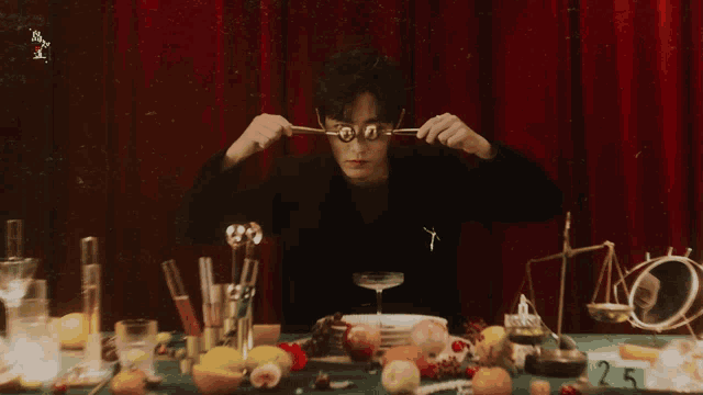 a man is sitting at a table with a plate of food and a sign that says 25