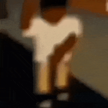 a blurry picture of a person in a white shirt holding a bottle .