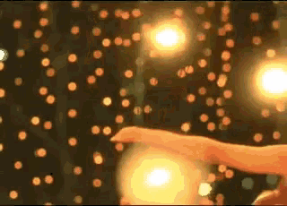 a person is dancing in front of a wall of lights