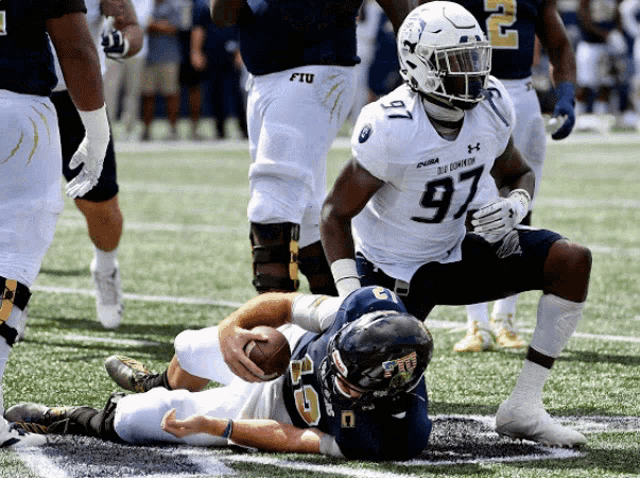 a football player with the number 97 on his jersey is being tackled