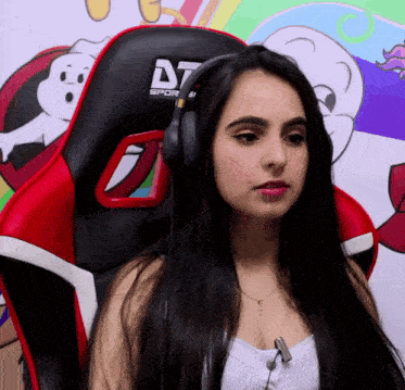 a woman wearing headphones is sitting in a dt sports chair