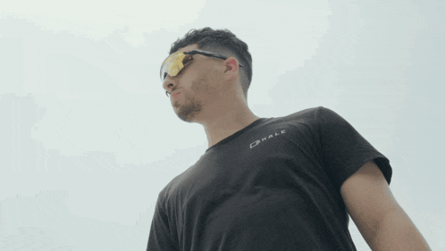 a man wearing sunglasses and a black shirt that says drale