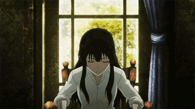 a girl in a white shirt sits in front of a window with her eyes closed