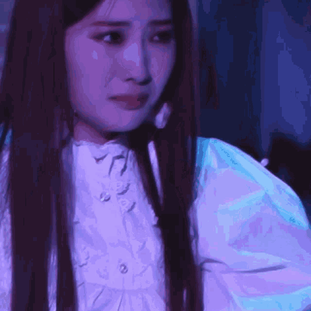 a close up of a woman 's face with purple and blue lights behind her