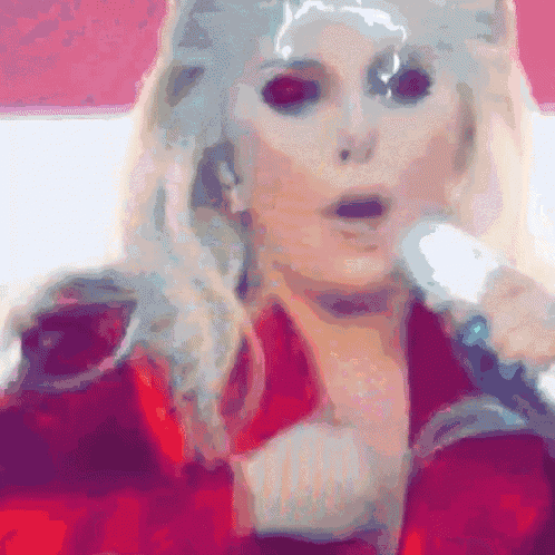 a woman singing into a microphone with her eyes closed