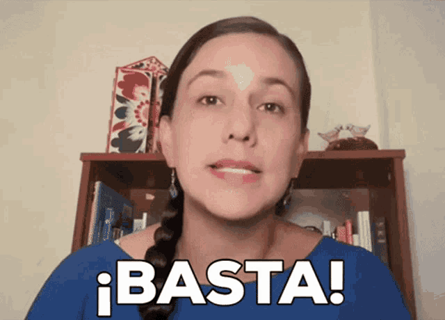 a woman in a blue shirt says basta in white letters