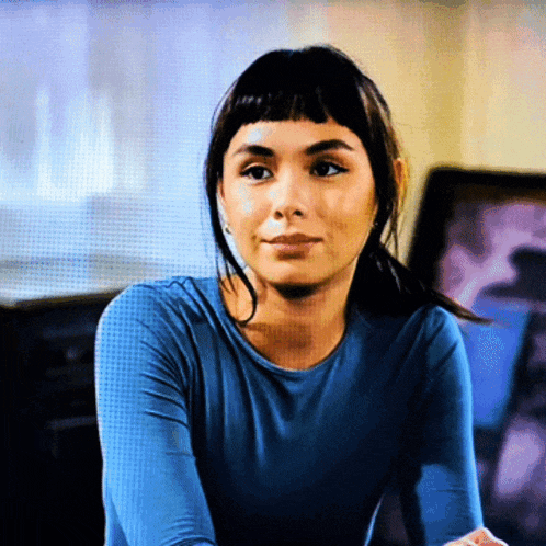 a woman in a blue shirt is sitting down