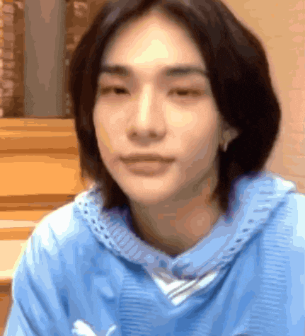 a close up of a person 's face in a blue sweater