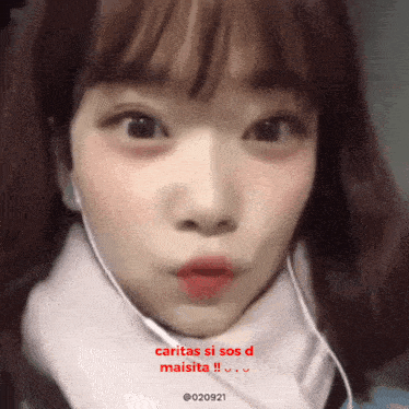 a close up of a girl 's face with the words caritas si sos d maisita written in red