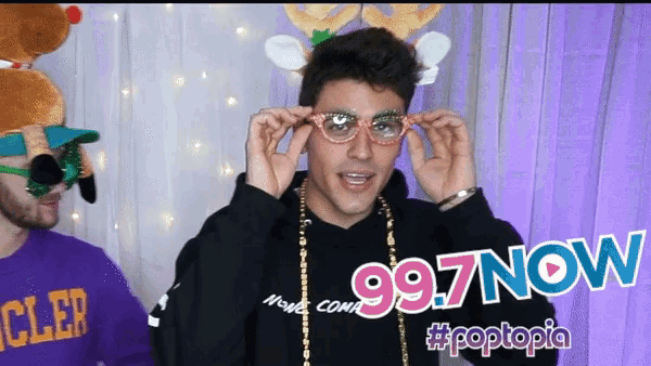 a man wearing glasses and a sweater that says 997 now on it