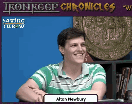 a man in a green and white shirt is smiling in front of an iron keep chronicles logo
