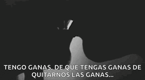 a black and white photo of a man and woman kissing with the words tengo ganas