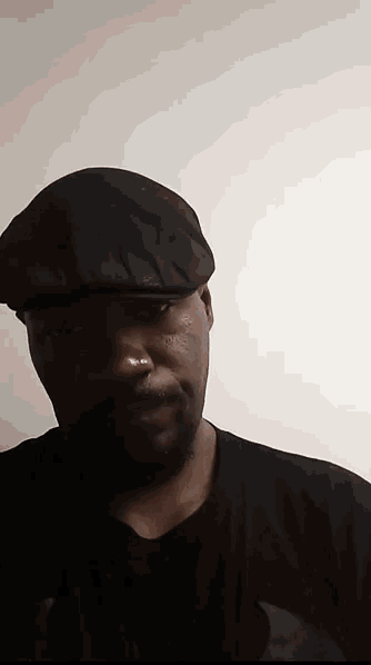 a man wearing a black hat is looking at the camera