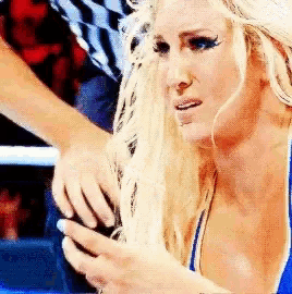 a woman in a blue top is being held by a referee