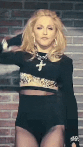 a woman wearing a black crop top with a cross on it