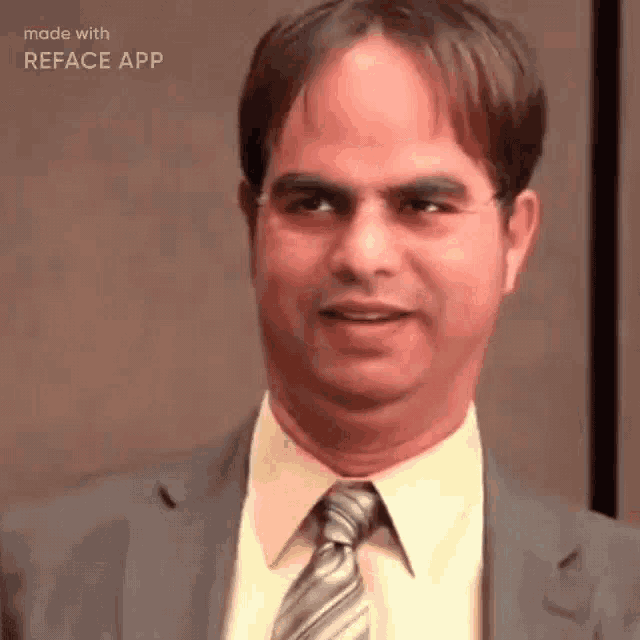 a man in a suit and tie is smiling for the camera .