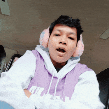 a man wearing headphones and a purple shirt that says fila on it