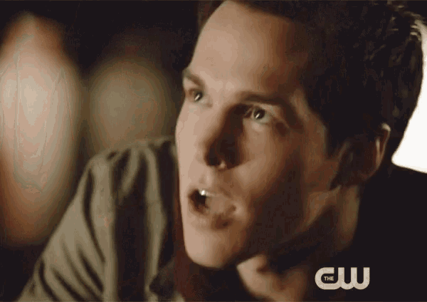 a close up of a man 's face with the cw logo in the background