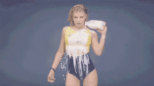 a woman in a bathing suit is holding a bottle of milk .