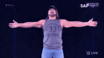 a man wearing a tank top with the number 33 on it is standing with his arms outstretched .