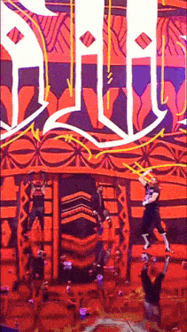 a group of people are performing on a stage in front of a large sign that says devil