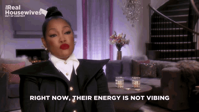 a woman is sitting in a living room with the words right now their energy is not vibing