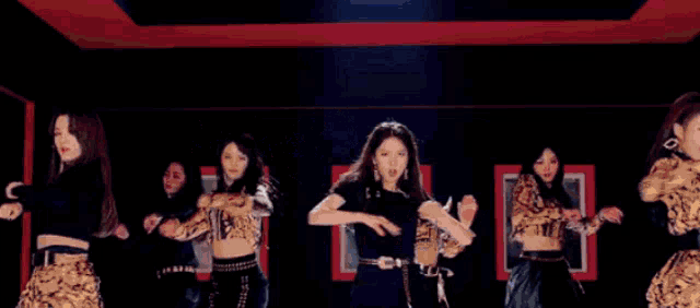 a woman in a suit and tie is dancing in front of a group of women in suits .
