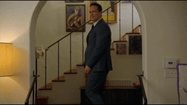 a man in a suit is walking up the stairs