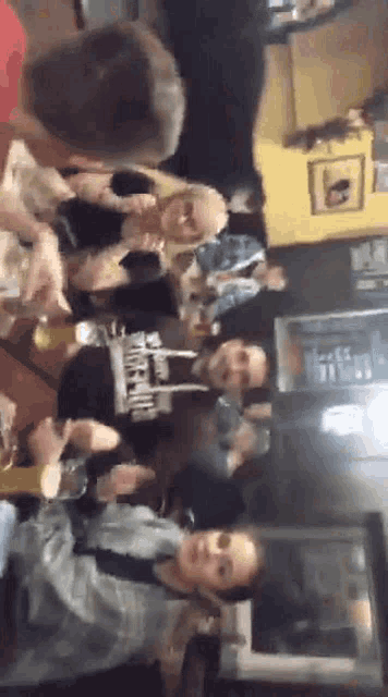 a group of people are sitting at tables in a restaurant .