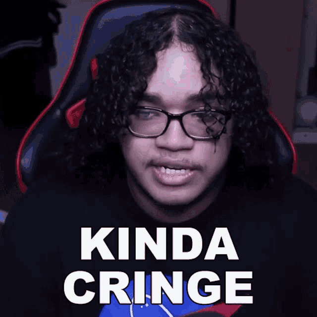 a man with curly hair and glasses is wearing a nasa shirt that says kinda cringe