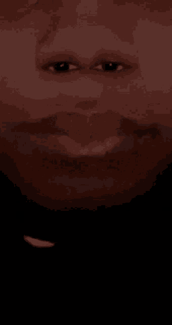 a close up of a man 's face with a mustache in the dark .