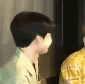 a man in a yellow shirt is standing next to another man in a yellow plaid shirt .