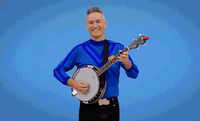 a man in a blue shirt holds a banjo