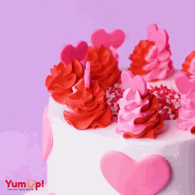 a cake with red and pink frosting and sprinkles with a yumup logo in the corner