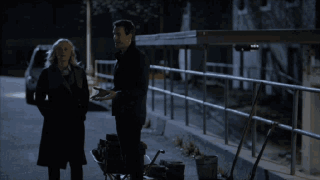 a man and a woman are walking down a street