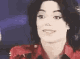 a close up of a person 's face with a red shirt on and a purple background .