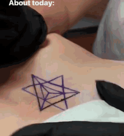 a person is getting a tattoo of a star on their chest .