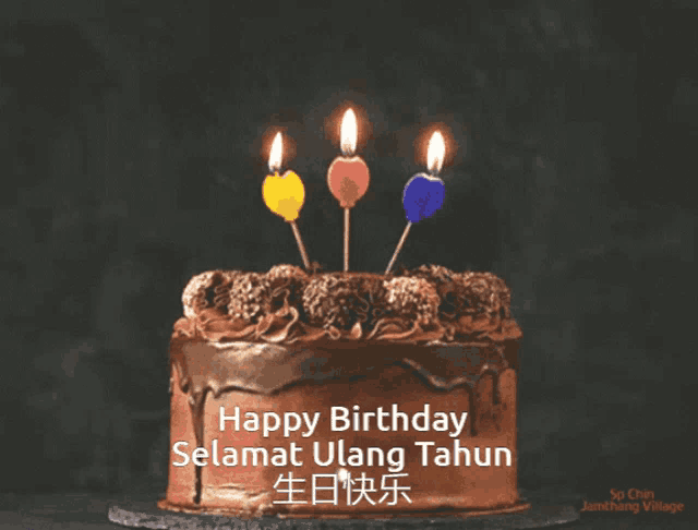 a chocolate birthday cake with three lit candles and the words happy birthday selamat ulang tahun on the bottom
