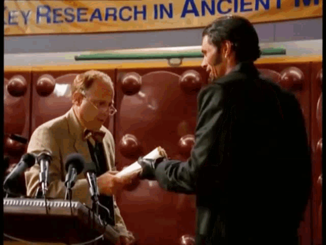 two men are standing in front of microphones in front of a banner that says research in ancient