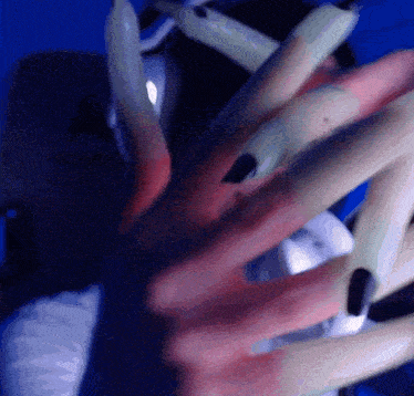 a close up of a woman 's hands with long nails