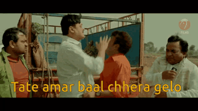 a group of men standing next to each other with the words " tate amar baal chhera gelo " in yellow