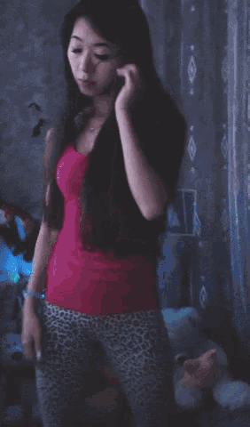 a woman in leopard print pants holds up her hand